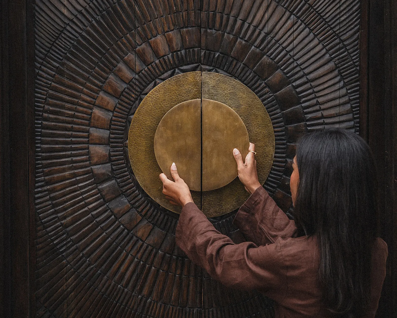 Carved entry door with custom-made brass handle at The Ark